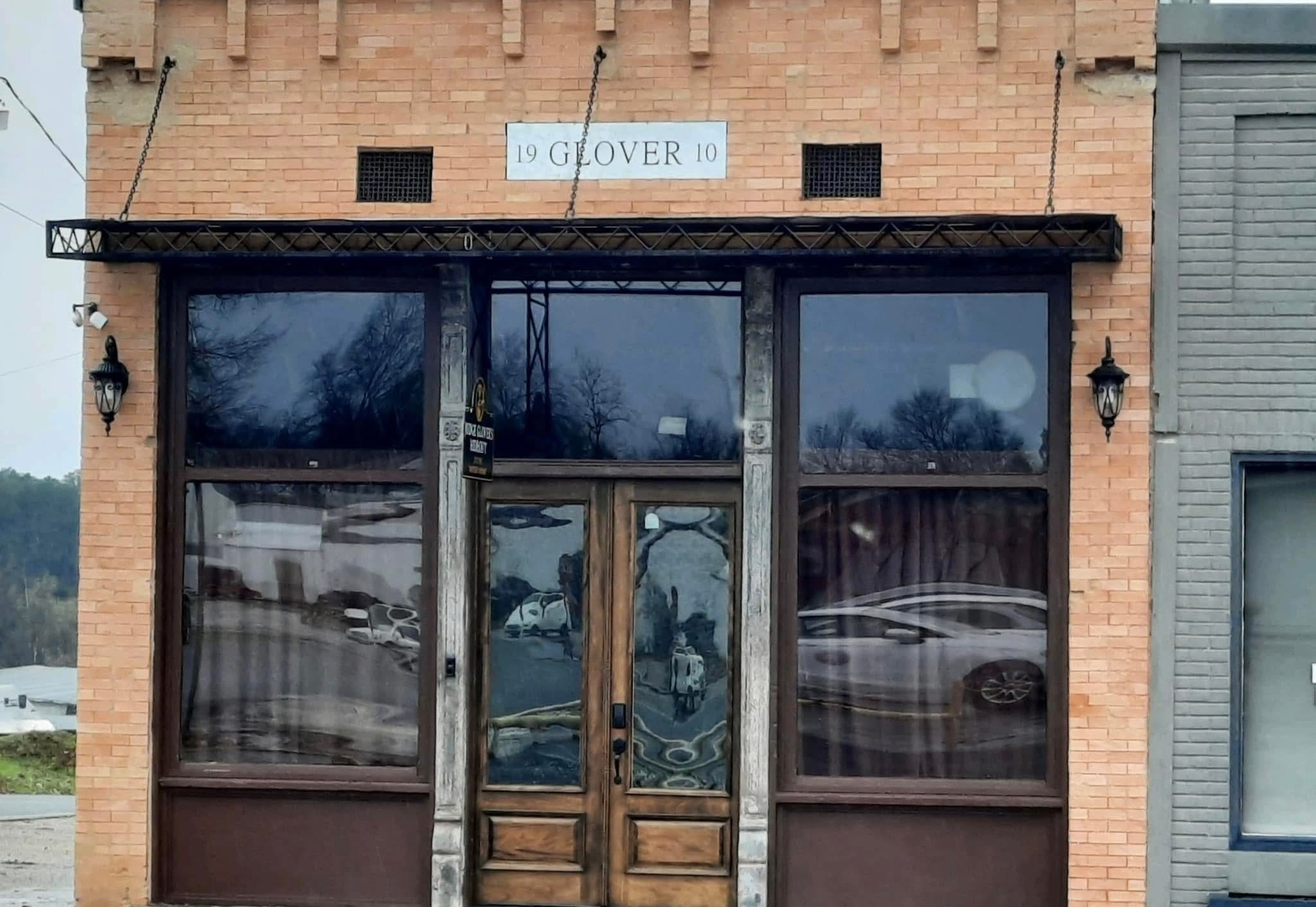 Restored Judge Glover’s Hideout storefront with exposed brick and tall glass doors